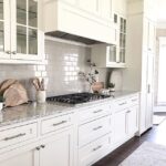 White kitchen shaker cabinets with grey subway tile backsplash .