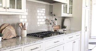 White kitchen shaker cabinets with grey subway tile backsplash .