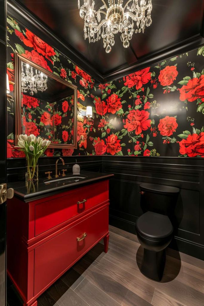 Bathroom with bold red floral wallpaper, black and red decor, a chandelier and a bouquet of white flowers on the vanity.