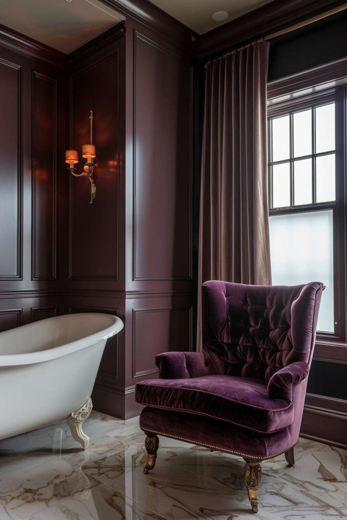 Luxurious bathroom with dark paneled walls, a claw-foot bathtub and a soft purple armchair on a marble floor. A wall light and a window provide light.