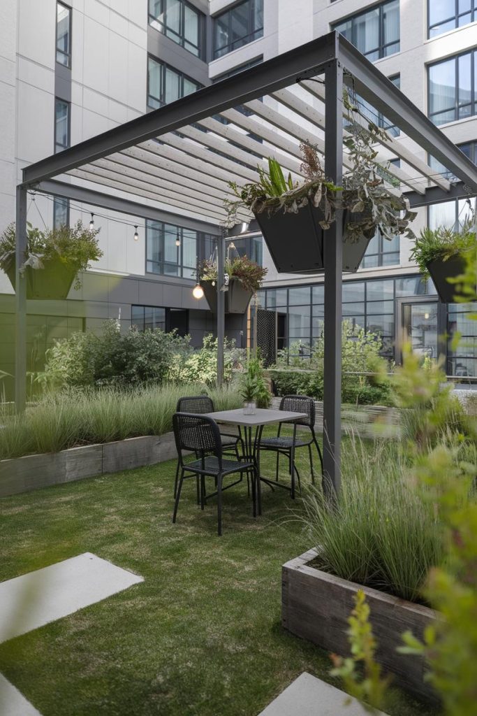 Modern outdoor seating area with table and chairs under a pergola surrounded by planters with green plants in a courtyard of a modern building.