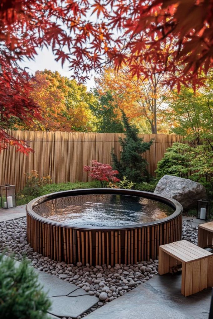 A tranquil backyard with a round tank surrounded by fall leaves and pebbles.