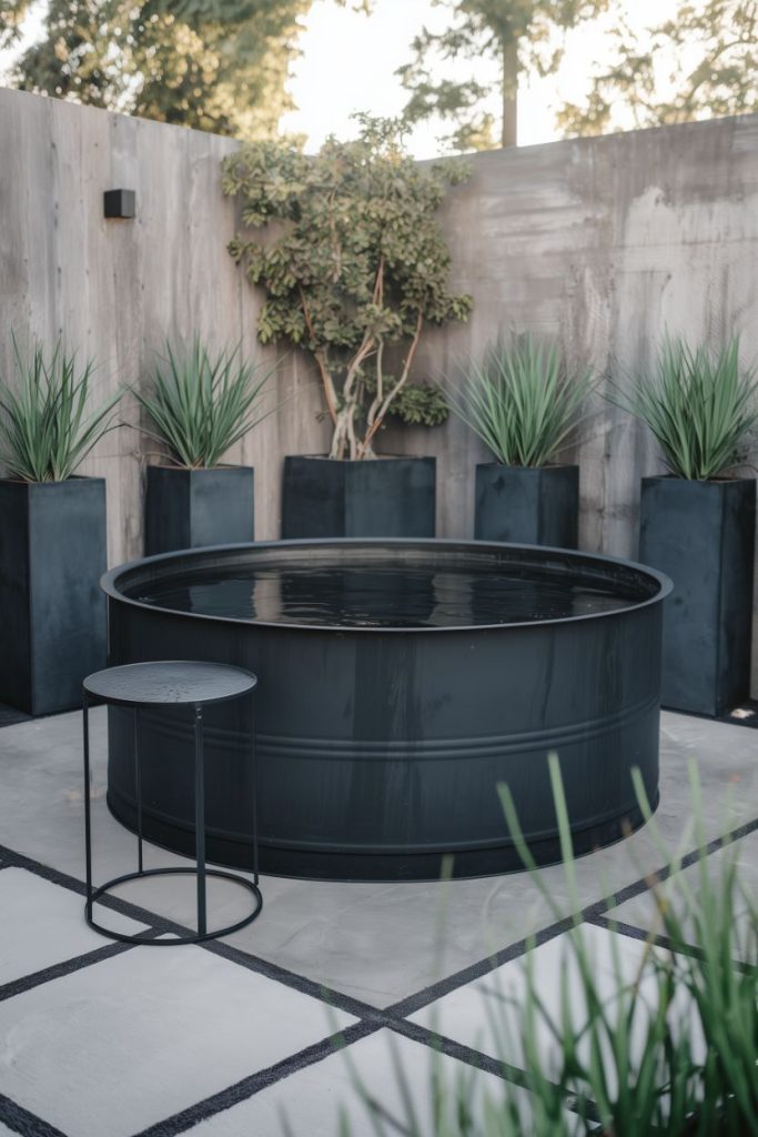 Modern outdoor setting with a black storage sink, concrete patio, potted plants and a side table.