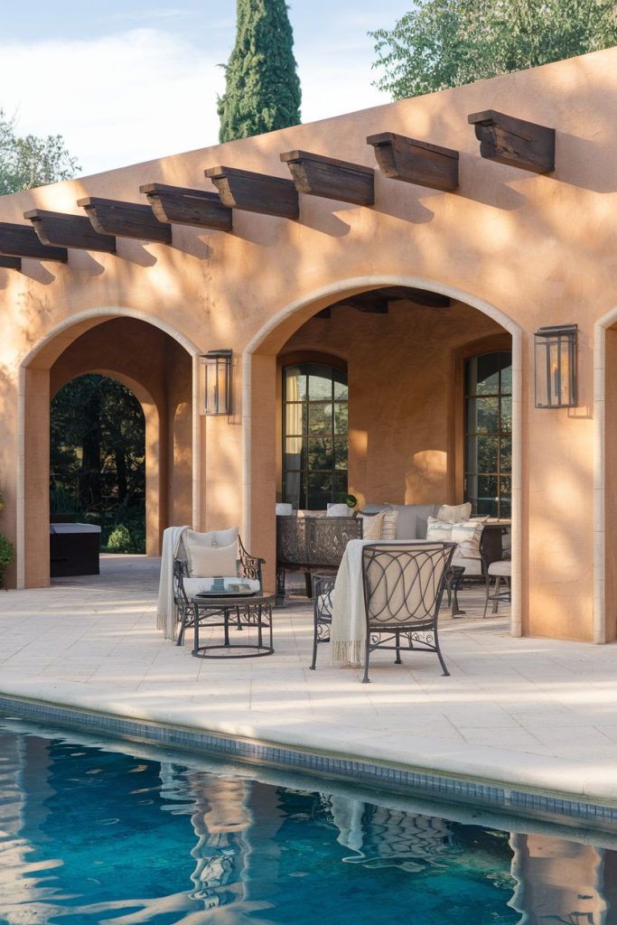 A Mediterranean-style terrace with arched openings, outdoor seating and a swimming pool in the foreground.