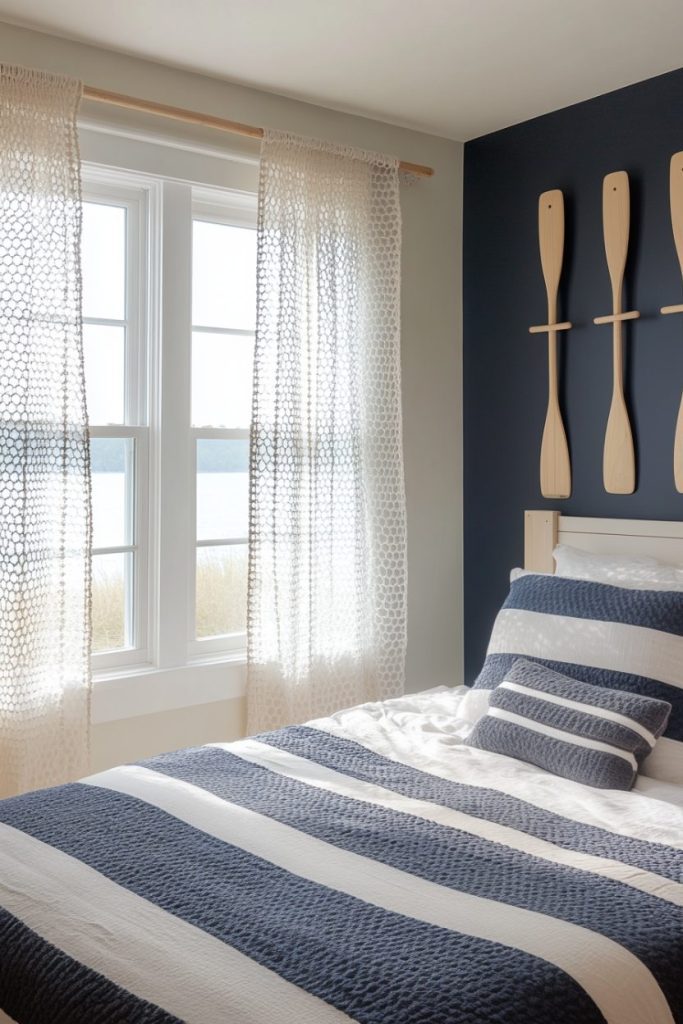 Nautical-themed bedroom with blue and white striped bedding, oars as wall decoration and a window with sheer curtains letting in natural light.