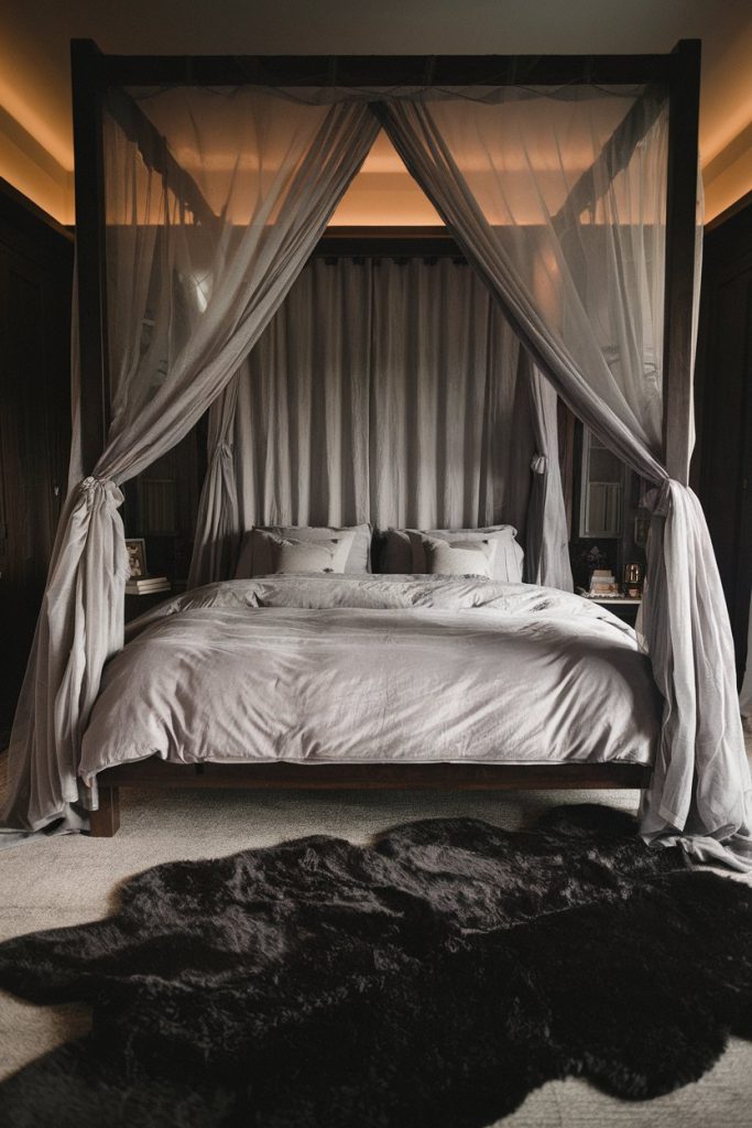 A four-poster bed with sheer curtains and gray linens sits in the center of a dimly lit room. There is a dark fur carpet on the floor in front of it.