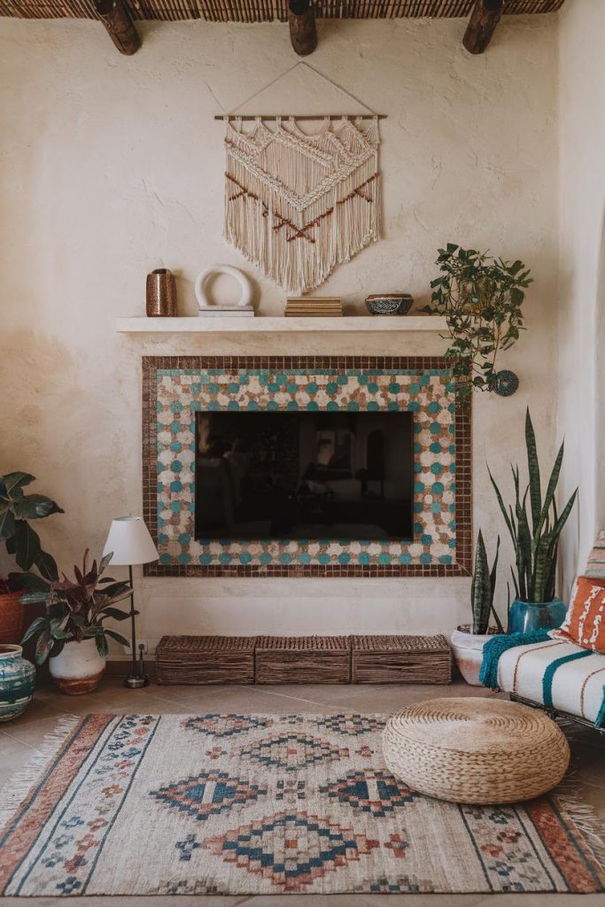 Cozy living room with a wall-mounted TV surrounded by colorful tiles, plants, a woven rug, a stool and macrame wall art.