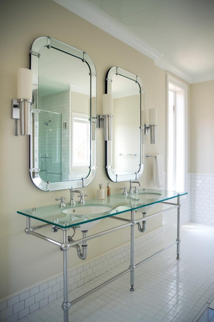 Elegant bathroom with two rectangular mirrors above a double sink with glass countertop and <a href=