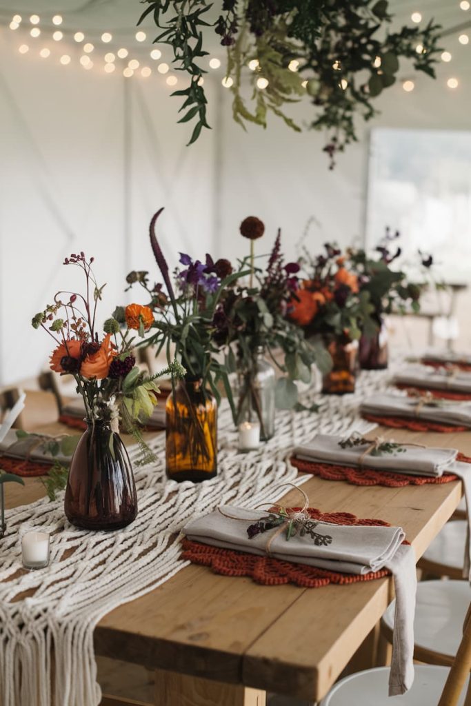 A rustic outdoor dining table with floral arrangements, woven placemats and fairy lights above creates an elegant atmosphere.