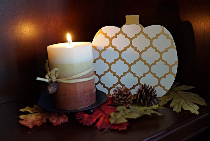 Autumn decor scene with pumpkin and candle