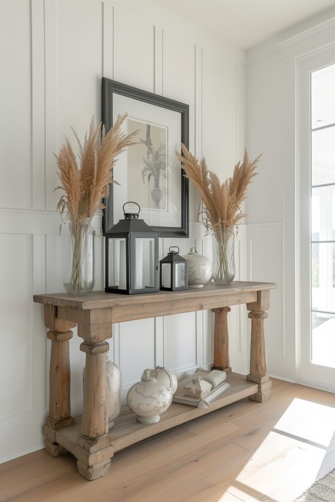 a wooden console table with white ceramics and vases full of pampas grass