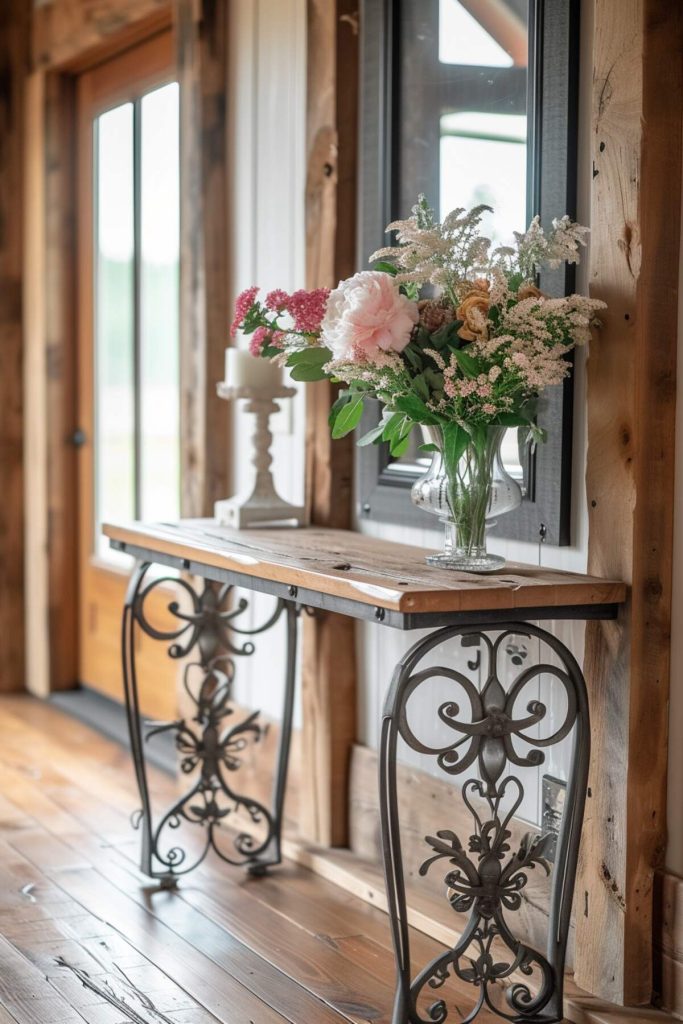 a wooden console table with iron frame, vibrant floral arrangement and an ornate candle holder