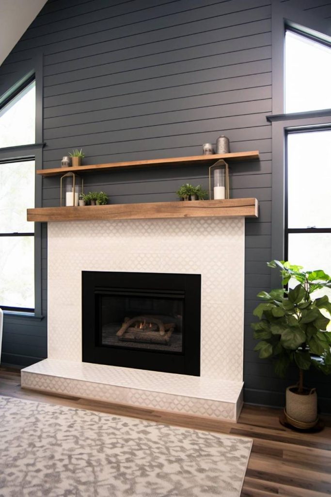 A modern living room fireplace with a black frame, white tiled surround and wooden paneling. Two shelves above provide space for plants and decorative items. A patterned carpet and a large plant lie nearby.