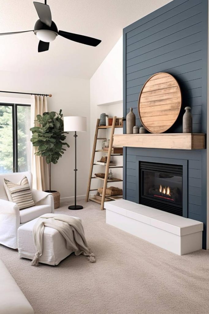 A modern living room features a white armchair, a floor lamp, and a fireplace with a wooden mantel. A blue shiplap accent wall and ladder shelf with decorative items complete the space.