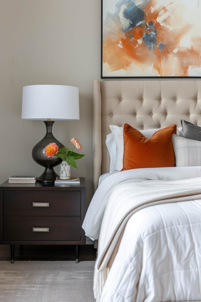 A bedside table with a unique lamp with a bulbous lamp base, artificial flowers and a few books