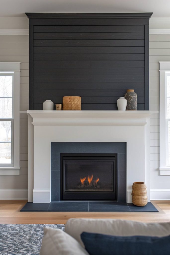 a living area with a black accent wall with shiplap on a white fireplace with minimal decorations such as rattan pieces, white vases and fabric-wrapped vases