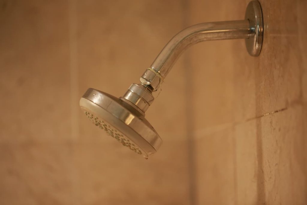 Interior of a hotel bathroom with dim lighting and a cozy atmosphere. The photo contains minimal grain and noise.