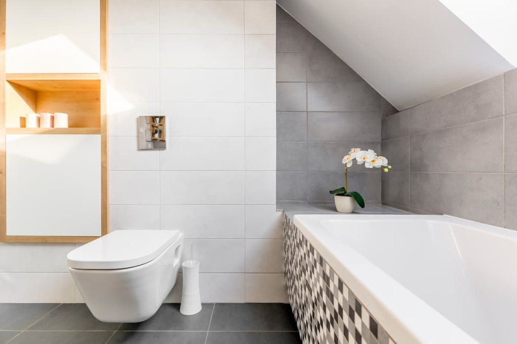 Bathroom in the attic with tiled walls and bathtub