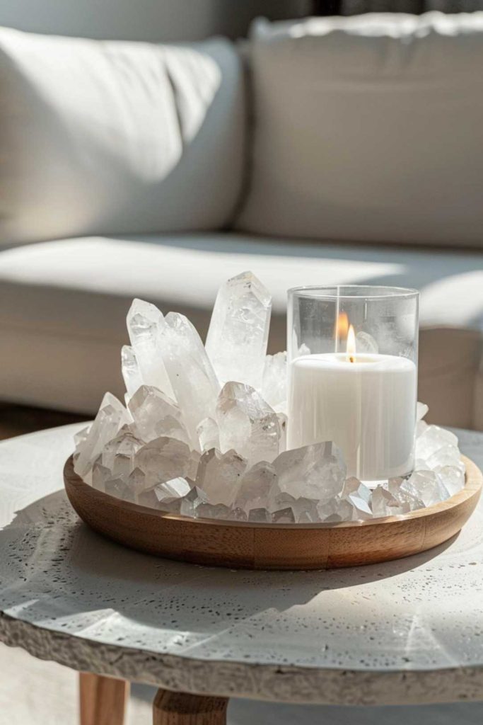 Chunks of clear quartz surround a white candle in a glass holder on a round wooden tray. Their natural facets reflect the gentle glow of the candlelight.