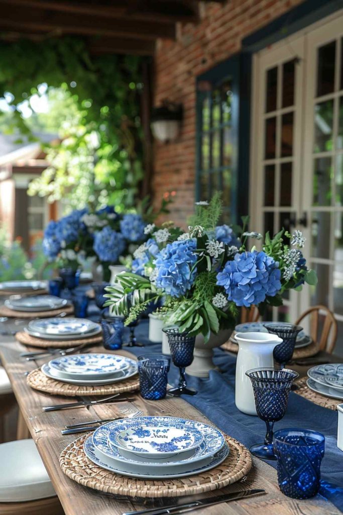 Outdoor table setting with deep blue linens and sapphire glassware paired with crisp white china and silverware