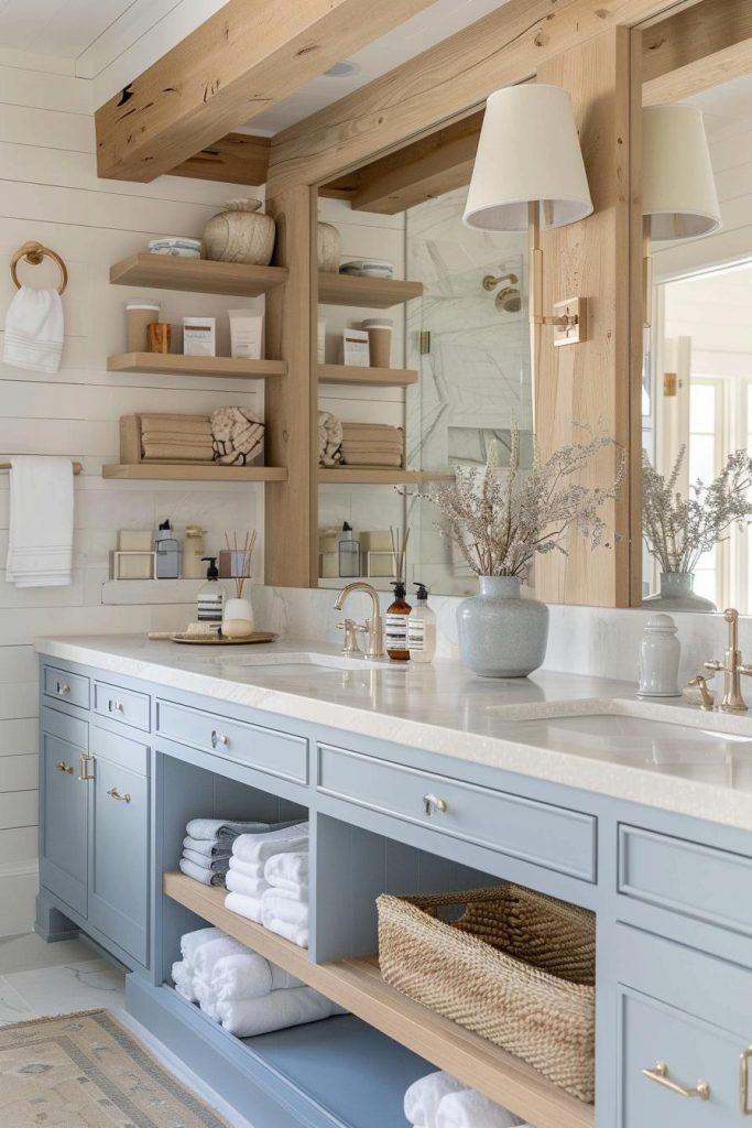 Natural wood shelves and muted blue tones create a bathroom space with a calming coastal essence.