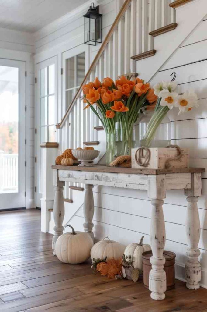 Combine elements from different seasons on one table. This table features seasonal decorations that breathe life into this entryway, while a rustic console table showcases a succession of fall squash and spring blossoms.