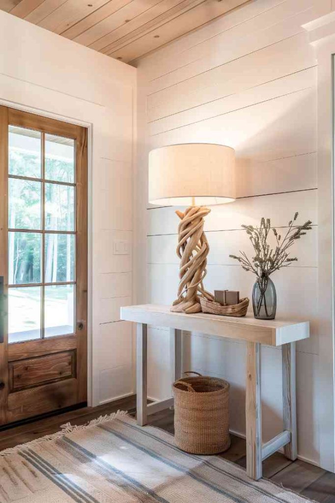 The focal point is an eye-catching lamp with a base made from twisting branches that bathes the farmhouse's entry table in an elegantly rustic light. This fascinating lamp not only illuminates the room, but also gives the entrance area a warm and inviting light.