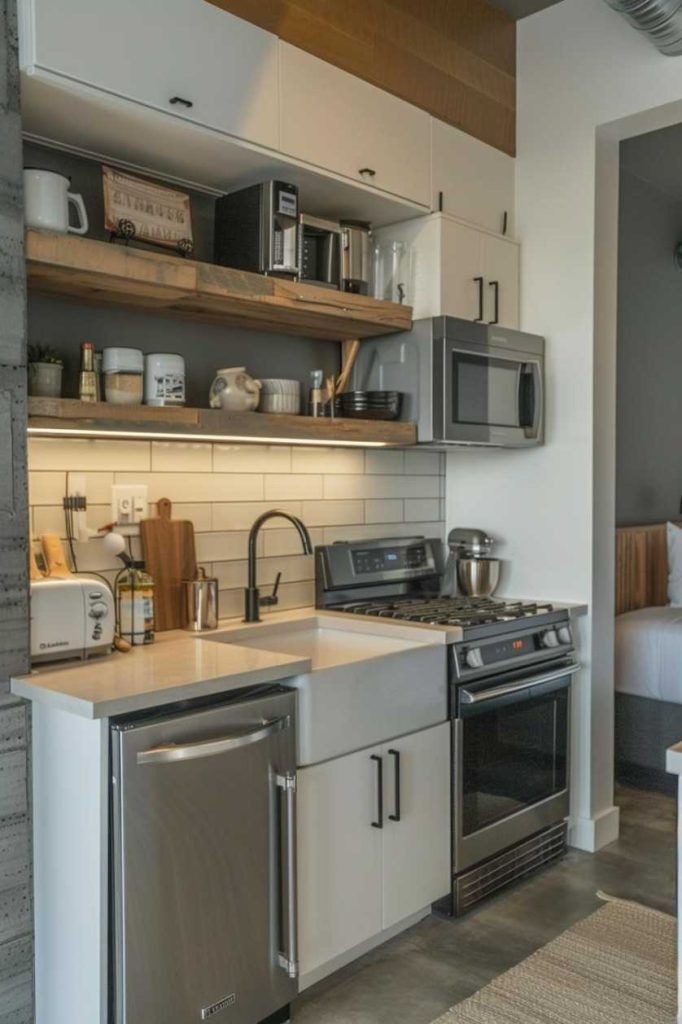 A modern kitchen with stainless steel devices, including refrigerator, oven and microwave, with white cupboards, wooden shelves, a toaster and a mixer on the worktops.