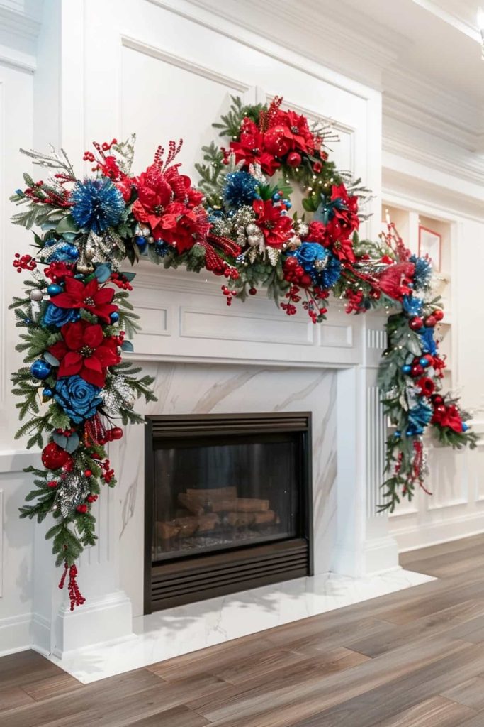 A fireplace that is adorned with a complex holiday garland and wreath. The decorations have red, blue and silver flowers as well as green pine branches and red berries that create a festive and lively display. The room has white walls and a wooden floor.