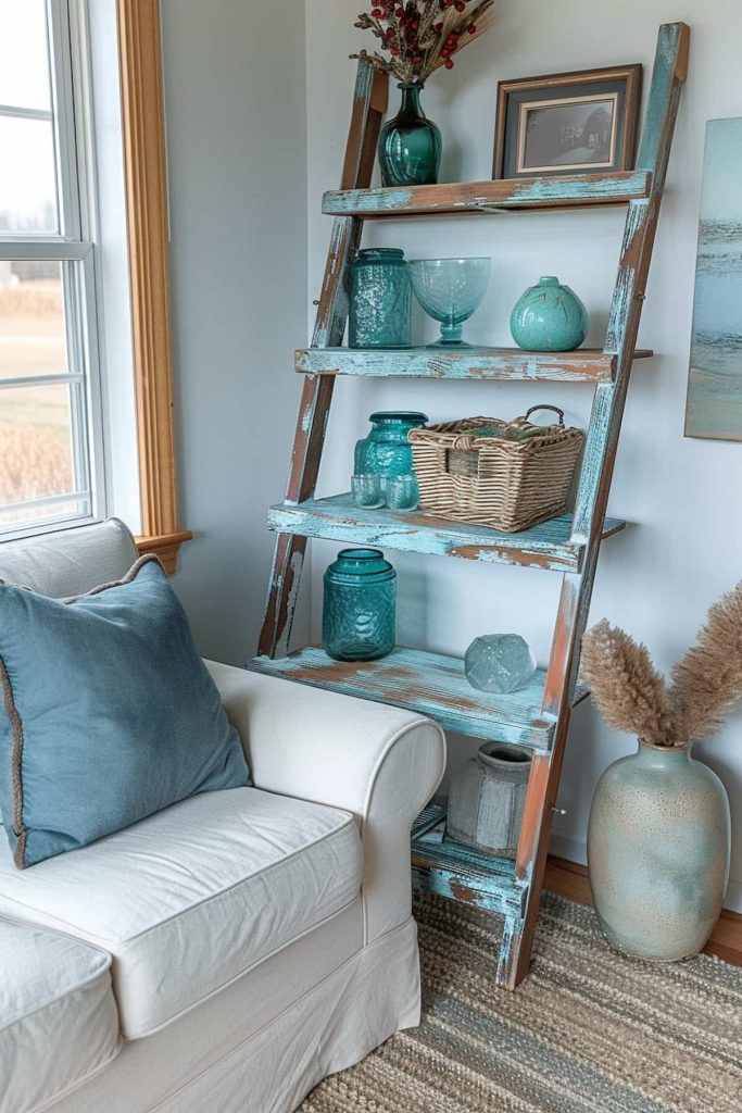 A corner has a white armchair with a blue pillow next to a rustic wooden conductor shelf with various turquoise vases, a basket and a dried plant arrangement in a vase on the floor.